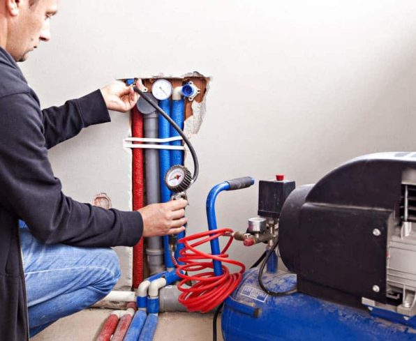 Plumber testing compressor leaks — Smart Water Metering in Auckland, NZ